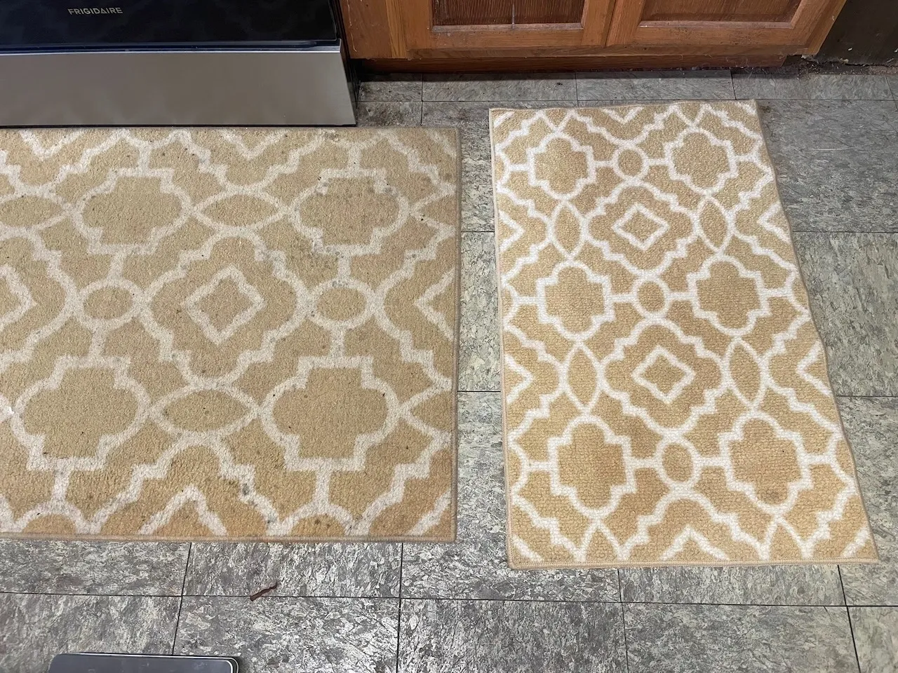 Two rugs are sitting on the floor next to a cabinet.