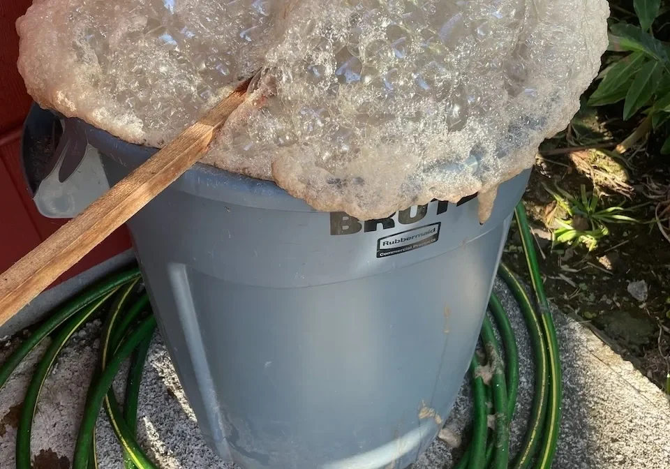 A bucket of ice sitting on top of the ground.